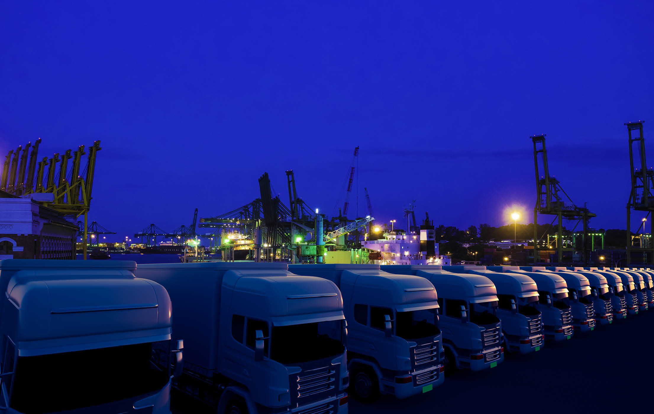 Row of cargo electric trucks against night